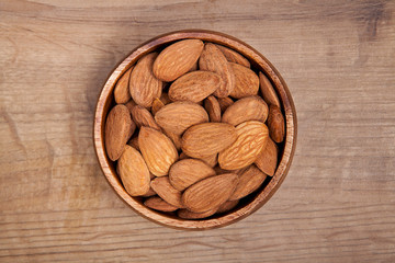 Almond in a bowls on wooden table. Healthy food and snack.