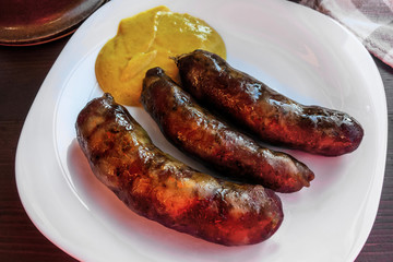 Three grilled sausage on plate.