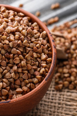 Fototapeta premium Grain buckwheat on a gray wooden background