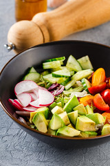 Vegan buddha bowl. Healthy vegetarian salad with cherry tomatoes, cucumber, radish,, avocado and lettuce.