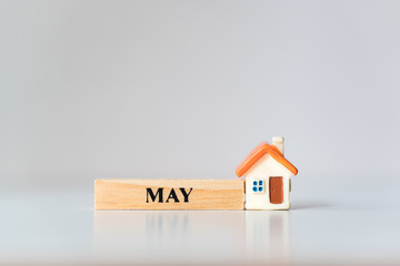 Miniature house with May wooden block using as property real estate concept
