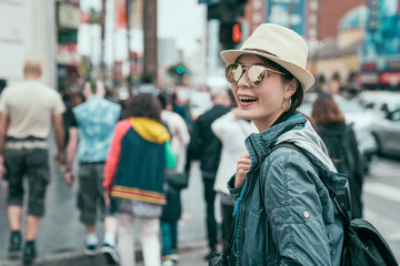 Emotional portrait of happy and cheerful beautiful teenager asian girl tourist walking through...