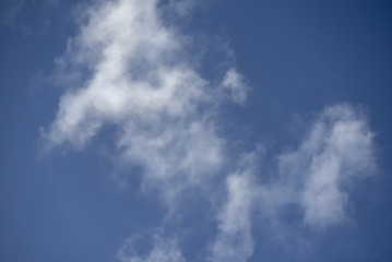 Naklejka na ściany i meble Blue clear sky with white feathery clouds.