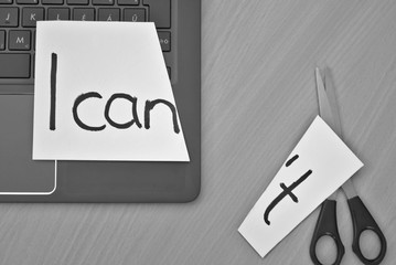 I can, I can't. White paper, notebook and scissors on a desk with a message I can
