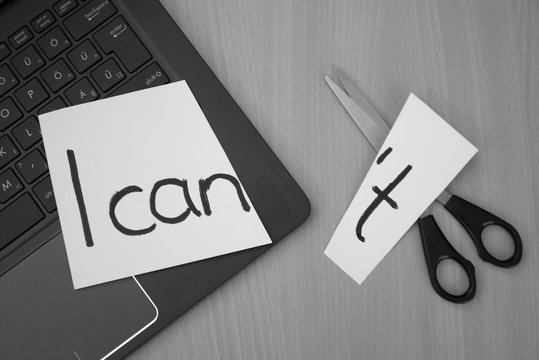 I can, I can't. White paper, notebook and scissors on a desk with a message I can