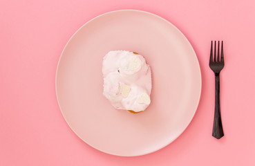 Cake on a pink plate. Pink background. Minimal concept.