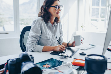 Female photographer retouching photos in office