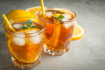Glasses of cold ice tea with lemon, ice, mint on background. Homemade lemonade. Spring and summer drinks and beverages concept.