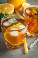 Glasses of cold ice tea with lemon, ice, mint on background. Homemade lemonade. Spring and summer drinks and beverages concept.