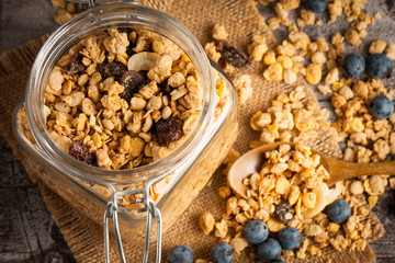 Healthy breakfast concept with oat flakes and fresh berries on rustic background. Food made of granola and muesli. Healthy banana smoothie with blackberries, honey and milk.