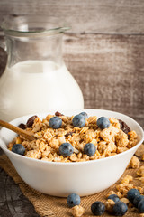 Healthy breakfast concept with oat flakes and fresh berries on rustic background. Food made of granola and muesli. Healthy banana smoothie with blackberries, honey and milk.