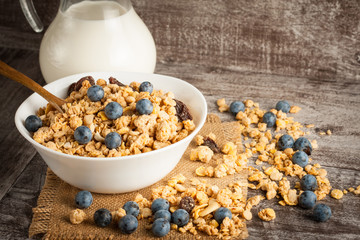 Healthy breakfast concept with oat flakes and fresh berries on rustic background. Food made of granola and muesli. Healthy banana smoothie with blackberries, honey and milk.