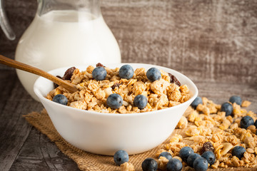 Healthy breakfast concept with oat flakes and fresh berries on rustic background. Food made of granola and muesli. Healthy banana smoothie with blackberries, honey and milk.
