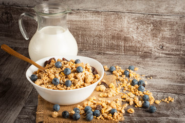 Healthy breakfast concept with oat flakes and fresh berries on rustic background. Food made of granola and muesli. Healthy banana smoothie with blackberries, honey and milk.