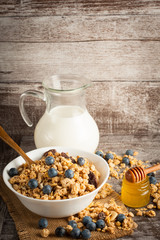Healthy breakfast concept with oat flakes and fresh berries on rustic background. Food made of granola and muesli. Healthy banana smoothie with blackberries, honey and milk.