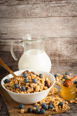 Healthy breakfast concept with oat flakes and fresh berries on rustic background. Food made of granola and muesli. Healthy banana smoothie with blackberries, honey and milk.