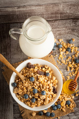 Healthy breakfast concept with oat flakes and fresh berries on rustic background. Food made of granola and muesli. Healthy banana smoothie with blackberries, honey and milk.