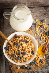 Healthy breakfast concept with oat flakes and fresh berries on rustic background. Food made of granola and muesli. Healthy banana smoothie with blackberries, honey and milk.