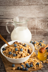 Healthy breakfast concept with oat flakes and fresh berries on rustic background. Food made of granola and muesli. Healthy banana smoothie with blackberries, honey and milk.