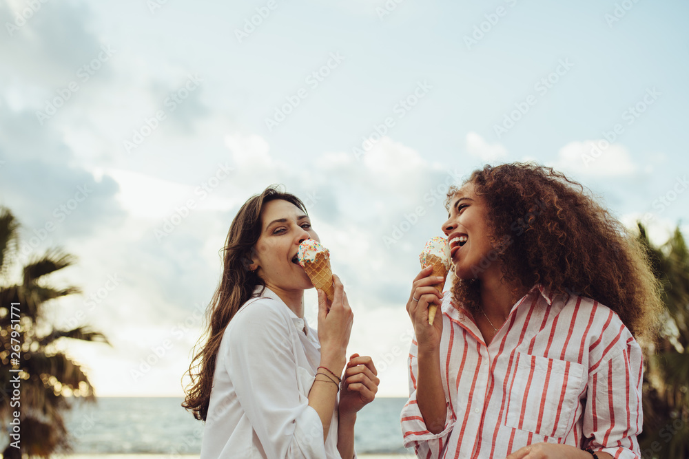 Wall mural woman friends eating ice cream together