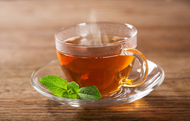 cup of tea with mint on wooden table
