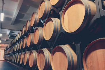 Oak barrels with cognac in dark cellar. Modern production of cognac with the observance of age-old traditions. close-up