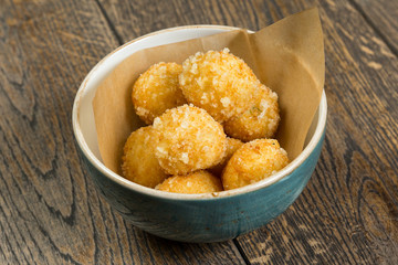 fried cheese balls in breading on a wooden table
