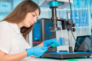 Woman worker in control of Resin LCD / DLP / SLA 3D Printer in technology lab
