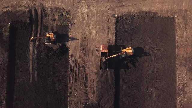 Drone eye view of construction site with machinery, truck, excavator.