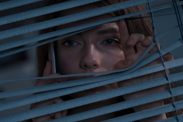 The woman with the phone peeping out the window