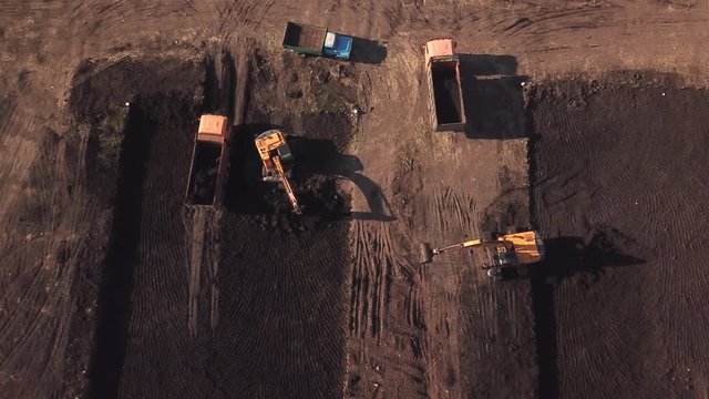 Aerial construction site with machinery, truck, excavator.