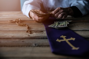 Priest counting money in his hand.