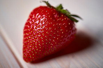 Closeup of fresh juicy red strawberry on  white  table
