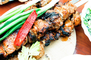 Grilled Caucasian kebab with onion and pepper salad on the table