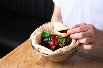 man eating in restaurant. man hold mussel. pizza with mussels on table restaurant traditional pizza with basil leaf