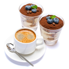 Classic tiramisu dessert with blueberries in a glass and cup of coffee isolated on a white background with clipping path