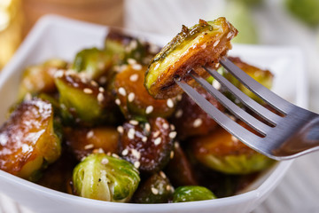 Roasted Brussels sprouts in a white bowl on a wooden background