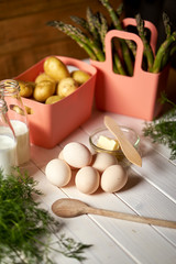 Fototapeta na wymiar Fresh asparagus potatoes and eggs on white kitchen table