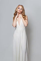 Fototapeta premium Fashion beauty portrait of beautiful woman in white dress posing on white background