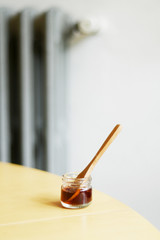 Jar of honey with wooden spoon on a table
