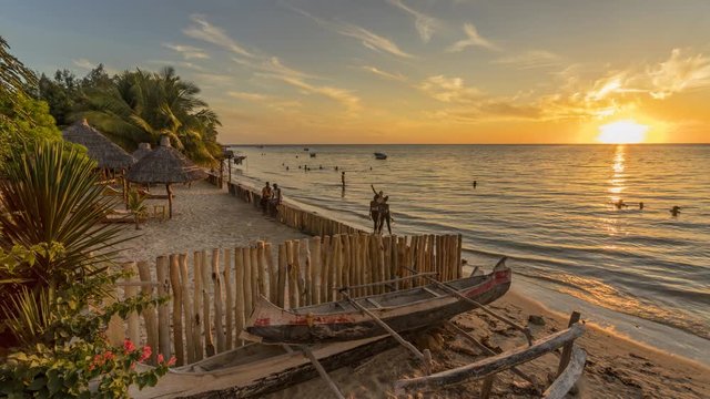 Sunset timelapse on the beach of Ifaty, Mangily, near Toliara / Tulear South West Madagascar. Tropical sandy beach, thatched huts, exotic vegetation, traditional wooden fishing boat and beautiful sky