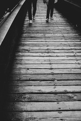 couple walk on a bridge in black and white