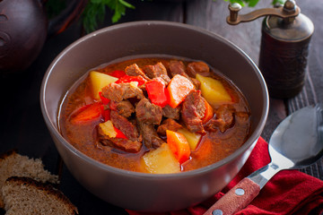 Traditional Hungarian goulash on the wooden table, horizontal