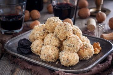 Snack cheese balls with prunes and walnuts on a metal platter, horizontal