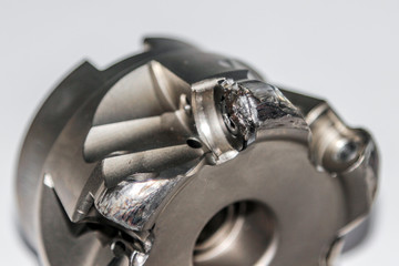Closeup of the damaged indexable milling cutter for CNC milling machine. Photo with selective focus  © kargona