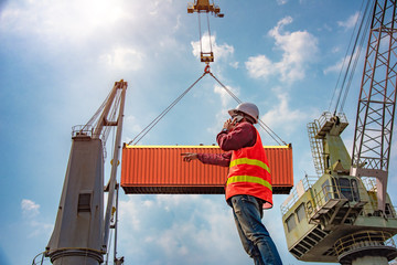 Fototapeta premium foreman, supervisor, loading master or worker talking on mobile phone with customer or client for delivery the goods or shipment cargo to detination agreements