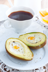 Baked quail egg avocado for breakfast on a white plate, selective focus