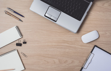 Workspace with diary or notebook and clipboard, laptop, mouse computer, keyboard, pencil, pen on wooden background