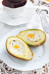 Baked quail egg avocado for breakfast on a white plate, selective focus