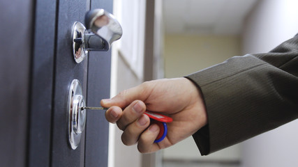 Obraz premium Close up of male hand unlocks a house's door with key